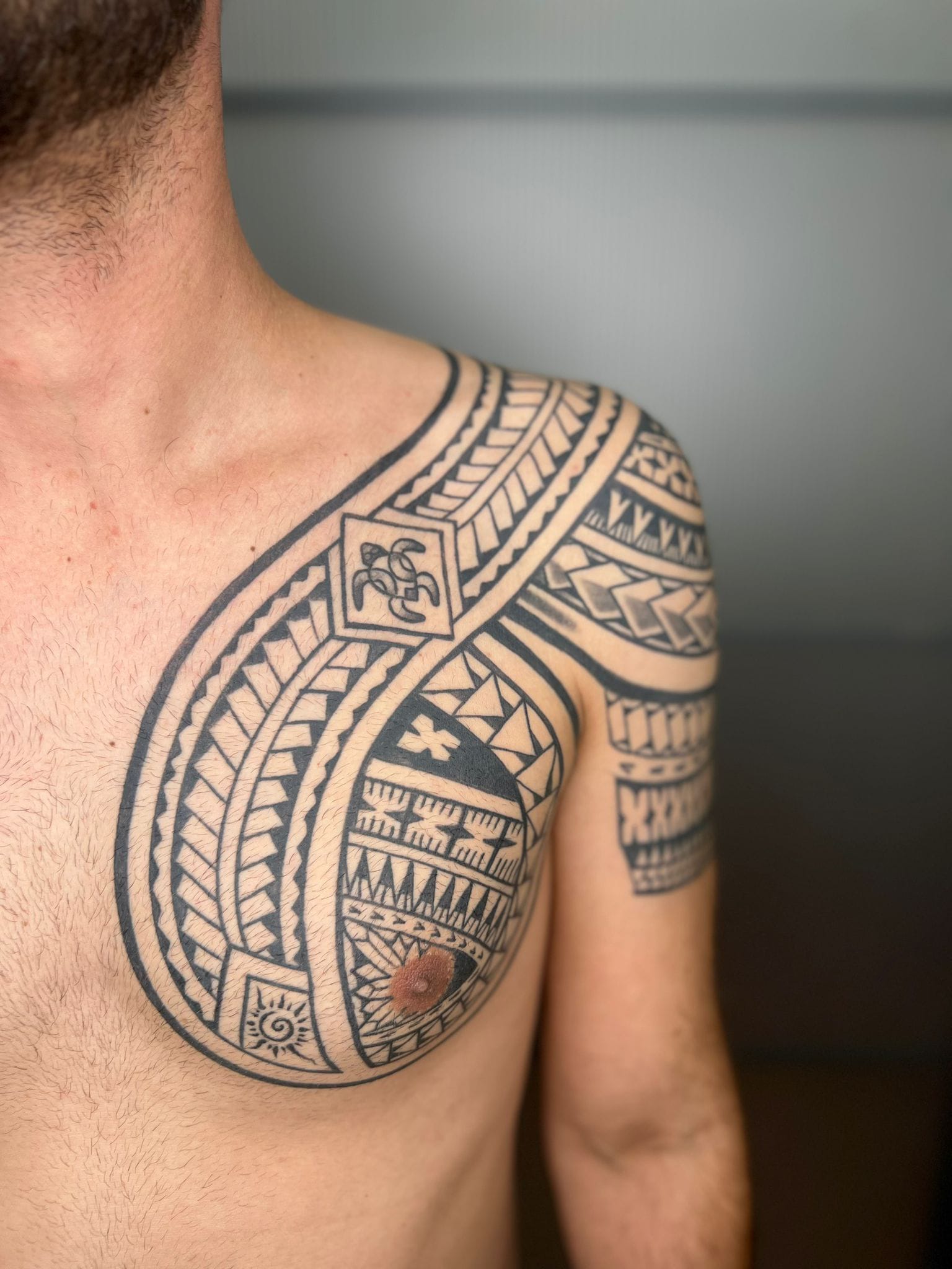 Detalle de tatuaje maorí en pecho y hombro